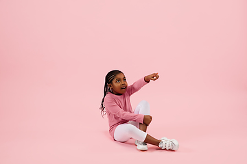 Image showing Childhood and dream about big and famous future. Pretty little girl isolated on coral pink background