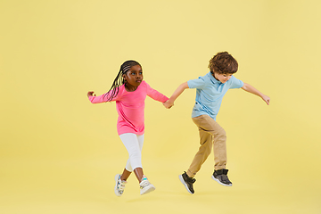 Image showing Childhood and dream about big and famous future. Pretty little kids isolated on yellow background