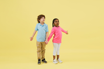 Image showing Childhood and dream about big and famous future. Pretty little kids isolated on yellow background