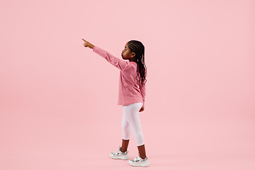 Image showing Childhood and dream about big and famous future. Pretty little girl isolated on coral pink background