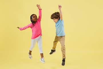 Image showing Childhood and dream about big and famous future. Pretty little kids isolated on yellow background