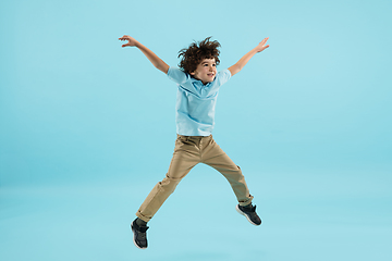 Image showing Childhood and dream about big and famous future. Pretty little boy isolated on blue background