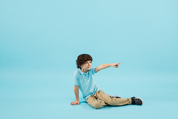 Image showing Childhood and dream about big and famous future. Pretty little boy isolated on blue background