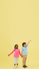 Image showing Childhood and dream about big and famous future. Pretty little kids isolated on yellow background