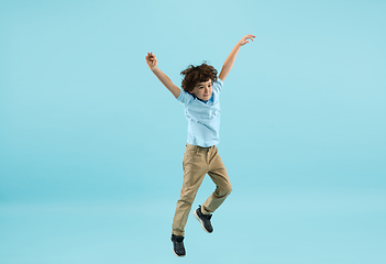 Image showing Childhood and dream about big and famous future. Pretty little boy isolated on blue background