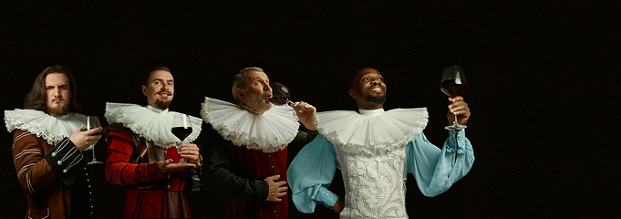 Image showing Medieval men as a royalty persons in vintage clothing on dark background. Concept of comparison of eras, modernity and renaissance, baroque style.