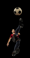 Image showing Young caucasian football, soccer player in action, motion isolated on black background, look from the bottom. Concept of sport, movement, energy and dynamic.