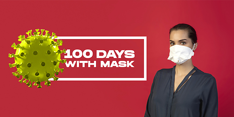 Image showing Woman in protective face mask isolated on red studio background. New rules of COVID spreading prevention, 100 days with masks