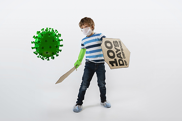 Image showing Little caucasian boy as a warrior in fight with coronavirus pandemic, with a shield, a sword and a toilet paper bandoleer.