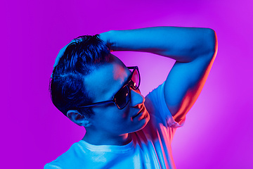 Image showing Caucasian man\'s portrait isolated on purple blue studio background in multicolored neon light