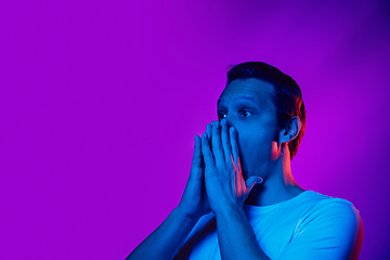 Image showing Caucasian man\'s portrait isolated on purple blue studio background in multicolored neon light