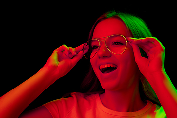 Image showing Caucasian woman\'s portrait isolated on black studio background in multicolored neon light