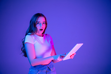 Image showing Caucasian woman\'s portrait isolated on blue studio background in multicolored neon light