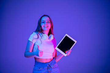 Image showing Caucasian woman\'s portrait isolated on blue studio background in multicolored neon light