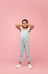 Image showing Happy longhair brunette little girl isolated on pink studio background. Looks happy, cheerful, sincere. Copyspace. Childhood, education, emotions concept