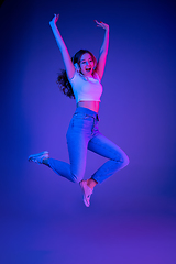 Image showing Caucasian woman\'s portrait isolated on blue studio background in multicolored neon light