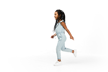 Image showing Happy longhair brunette little girl isolated on white studio background. Looks happy, cheerful, sincere. Copyspace. Childhood, education, emotions concept