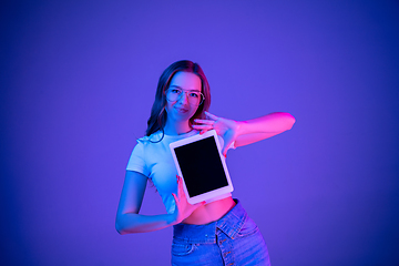 Image showing Caucasian woman\'s portrait isolated on blue studio background in multicolored neon light