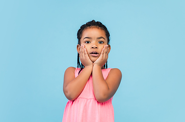 Image showing Happy longhair brunette little girl isolated on blue studio background. Looks happy, cheerful, sincere. Copyspace. Childhood, education, emotions concept