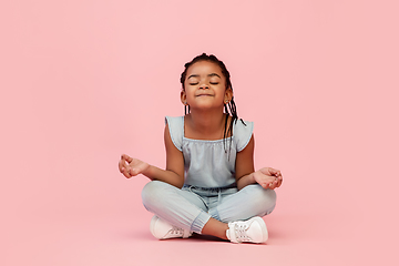 Image showing Happy longhair brunette little girl isolated on pink studio background. Looks happy, cheerful, sincere. Copyspace. Childhood, education, emotions concept