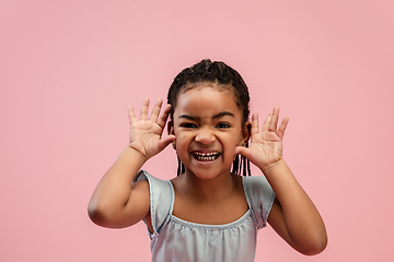 Image showing Happy longhair brunette little girl isolated on pink studio background. Looks happy, cheerful, sincere. Copyspace. Childhood, education, emotions concept