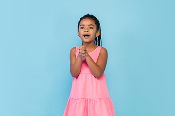 Image showing Happy longhair brunette little girl isolated on blue studio background. Looks happy, cheerful, sincere. Copyspace. Childhood, education, emotions concept