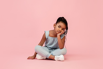 Image showing Happy longhair brunette little girl isolated on pink studio background. Looks happy, cheerful, sincere. Copyspace. Childhood, education, emotions concept