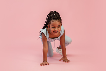 Image showing Happy longhair brunette little girl isolated on pink studio background. Looks happy, cheerful, sincere. Copyspace. Childhood, education, emotions concept