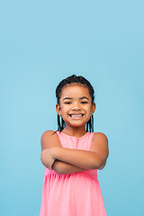 Image showing Happy longhair brunette little girl isolated on blue studio background. Looks happy, cheerful, sincere. Copyspace. Childhood, education, emotions concept