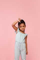 Image showing Happy longhair brunette little girl isolated on pink studio background. Looks happy, cheerful, sincere. Copyspace. Childhood, education, emotions concept