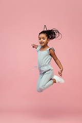 Image showing Happy longhair brunette little girl isolated on pink studio background. Looks happy, cheerful, sincere. Copyspace. Childhood, education, emotions concept
