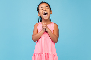 Image showing Happy longhair brunette little girl isolated on blue studio background. Looks happy, cheerful, sincere. Copyspace. Childhood, education, emotions concept