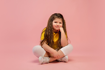 Image showing Happy caucasian little girl isolated on studio background. Looks happy, cheerful, sincere. Copyspace. Childhood, education, emotions concept