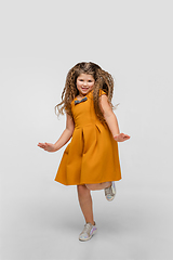 Image showing Happy caucasian little girl isolated on studio background. Looks happy, cheerful, sincere. Copyspace. Childhood, education, emotions concept