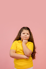 Image showing Happy caucasian little girl isolated on studio background. Looks happy, cheerful, sincere. Copyspace. Childhood, education, emotions concept