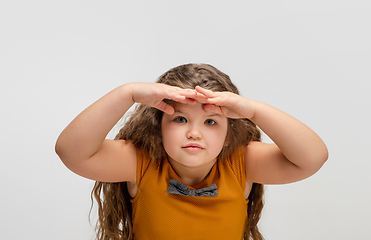 Image showing Happy caucasian little girl isolated on studio background. Looks happy, cheerful, sincere. Copyspace. Childhood, education, emotions concept