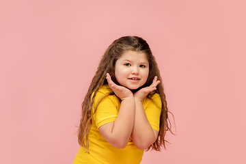 Image showing Happy caucasian little girl isolated on studio background. Looks happy, cheerful, sincere. Copyspace. Childhood, education, emotions concept