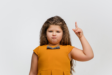 Image showing Happy caucasian little girl isolated on studio background. Looks happy, cheerful, sincere. Copyspace. Childhood, education, emotions concept