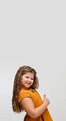 Image showing Happy caucasian little girl isolated on studio background. Looks happy, cheerful, sincere. Copyspace. Childhood, education, emotions concept