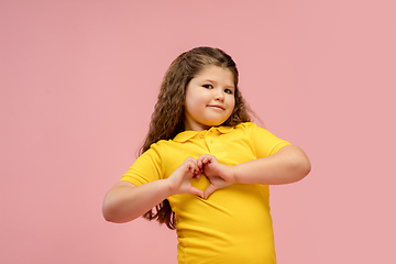 Image showing Happy caucasian little girl isolated on studio background. Looks happy, cheerful, sincere. Copyspace. Childhood, education, emotions concept