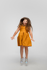 Image showing Happy caucasian little girl isolated on studio background. Looks happy, cheerful, sincere. Copyspace. Childhood, education, emotions concept