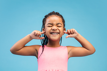 Image showing Happy longhair brunette little girl isolated on blue studio background. Looks happy, cheerful, sincere. Copyspace. Childhood, education, emotions concept