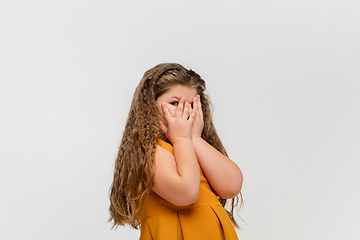 Image showing Happy caucasian little girl isolated on studio background. Looks happy, cheerful, sincere. Copyspace. Childhood, education, emotions concept