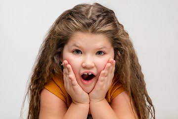 Image showing Happy caucasian little girl isolated on studio background. Looks happy, cheerful, sincere. Copyspace. Childhood, education, emotions concept