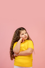 Image showing Happy caucasian little girl isolated on studio background. Looks happy, cheerful, sincere. Copyspace. Childhood, education, emotions concept