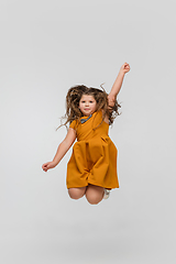 Image showing Happy caucasian little girl isolated on studio background. Looks happy, cheerful, sincere. Copyspace. Childhood, education, emotions concept