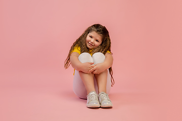 Image showing Happy caucasian little girl isolated on studio background. Looks happy, cheerful, sincere. Copyspace. Childhood, education, emotions concept