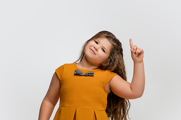 Image showing Happy caucasian little girl isolated on studio background. Looks happy, cheerful, sincere. Copyspace. Childhood, education, emotions concept