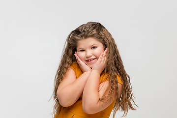 Image showing Happy caucasian little girl isolated on studio background. Looks happy, cheerful, sincere. Copyspace. Childhood, education, emotions concept