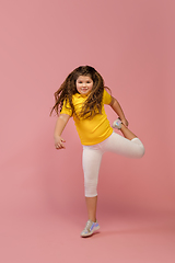 Image showing Happy caucasian little girl isolated on studio background. Looks happy, cheerful, sincere. Copyspace. Childhood, education, emotions concept